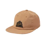 Gorra color beige con visera plana y parche con el logo de la marca Roark bordado en el frente.