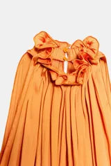 Mono largo satinado color naranja, de corte amplio con pierna ancha, cuello redondo y manga sisa, con detalle de tejido arrugado y cierre en la espalda.