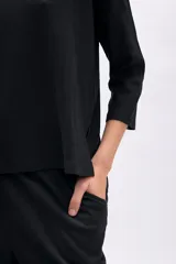 Remera negra de manga tres cuartos, corte oversize y textura acanalada.