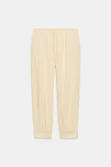 Pantalón bombacho de tiro medio, confeccionado en hilatura con mezcla de viscosa, con estampado de rayas verticales en tonos beige y amarillo claro, cintura elástica ajustable con cordón y puños en los tobillos.