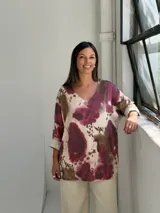 Sweater de punto con cuello en V y mangas tres cuartos con dobladillo. Presenta un estampado abstracto con manchas en tonos bordó, marrón y crema.