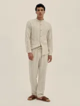 Camisa de manga larga con cuello tipo Mao, a rayas verticales color beige y blanco.