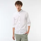 Camisa de lino mezclado color blanco, con cuello con botones, manga larga y botones frontales en contraste de efecto madera.