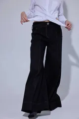 Pantalón de tiro medio y corte ancho, confeccionado en una mezcla de lino y algodón. Presenta costuras a la vista en contraste, bolsillos delanteros y traseros con detalles de remaches.