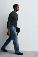 Jeans de corte recto en tono azul clásico con efecto lavado, tiro medio y diseño de cinco bolsillos con cierre frontal de botones.