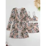 Conjunto de traje de baño de tres piezas con estampado de hojas tropicales en tonos blanco y negro. Incluye un top tipo tankini con cordón ajustable en el centro, un short de tiro alto y una camisa abierta de manga larga tipo salida de baño.