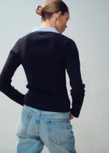 Jersey de punto grueso negro con mangas largas y cuello camisero superpuesto en color celeste.