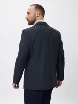 Blazer de tweed color azul marino con coderas en contraste, cierre frontal de botones y bolsillos laterales. Presenta un diseño clásico de corte regular.