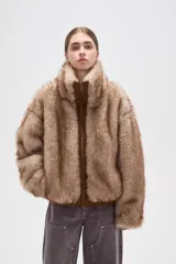 Campera de piel sintética en tono tostado, con cuello alto, cierre frontal y diseño holgado.