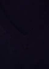 Buzo de tejido de punto fino en color azul marino, con cuello en pico y manga larga. Presenta terminaciones en canalé en puños y bajo.