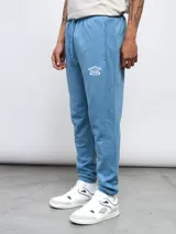 Pantalón de jogging celeste de felpa sin friza, con cintura elástica ajustable con cordón y logo de Umbro bordado en blanco.