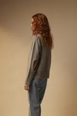 Sweater gris de tejido de punto liso con abertura en los codos.