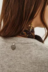 Sweater de punto color negro, con cuello redondo y mangas largas con puños acanalados.