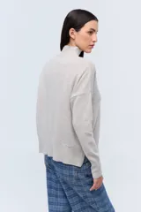 Polera tejida de punto confeccionada en lambswool color gris claro, con cuello alto y calce holgado.