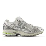 Championes urbanos New Balance modelo 1906R, con diseño inspirado en el running de los años 2000. Presentan una combinación de malla técnica y detalles sintéticos en tonos gris y blanco, con acentos en verde neón en la suela y el talón. Incorporan tecnología de amortiguación N-ergy, entresuela ACTEVA LITE y talón con ABZORB SBS para mayor estabilidad y confort.