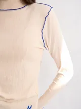 Polera básica de algodón en tejido rib, color turquesa, de manga larga, con hombreras y detalles de pespuntes en color contrastante en las terminaciones y el cuello.