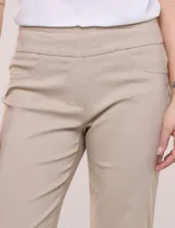 Pantalón de gabardina elastizada color beige, de corte recto, con bolsillos simulados en el frente y bolsillos aplicados en la parte trasera.
