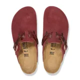 Zueco Birkenstock modelo Boston con diseño trenzado en el empeine, confeccionado en gamuza color bordó. Cuenta con una tira ajustable con hebilla metálica, plantilla de corcho anatómica y suela de goma negra.