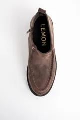 Bota corta de cuero vacuno en tono marrón oscuro, con diseño de costuras visibles en el empeine y suela de goma dentada tipo track.