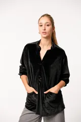 Buzo negro de terciopelo con escote en V y bolsillos frontales.