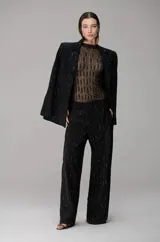 Blazer de sastrería negro con textura brillante y diseño estructurado, con solapas clásicas y corte recto.