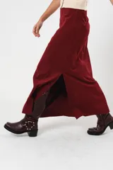 Falda larga color borgoña, confeccionada en tela suave con acabado tipo piel de durazno y cierre invisible lateral.