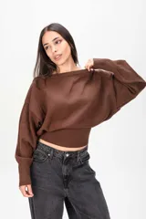 Sweater negro de punto con diseño holgado, escote bote y cintura ajustada con elástico ancho.