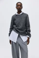 Buzo de punto suave en mezcla de mohair y lana, color gris oscuro. Modelo entallado con cuello redondo y hombros caídos. Puños y bajo con remate acanalado.