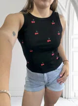 Musculosa negra de algodón con cuello redondo y estampado de cerezas rojas.
