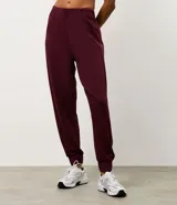 Pantalón deportivo tipo jogger color bordó, confeccionado en tejido de modal con poliéster y elastano. Presenta cintura fija, recortes estratégicos en el diseño y terminación ajustada en la botamanga.