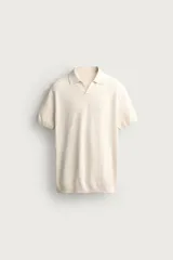 Polo de punto color beige, de corte regular fit y diseño estructurado, con cuello solapa, escote en V y manga corta con acabados en rib.