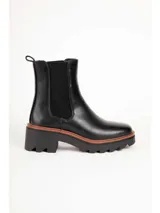 Bota tipo Chelsea de color negro, con elásticos laterales, suela track y taco cuadrado con detalle en tono marrón.