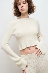 Sweater color crema de tejido de punto con cuello redondo y mangas largas.