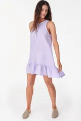 Vestido corto lila de lino, sin mangas, con escote redondo, cartera de botones de nácar en el frente y volado fruncido en el ruedo.