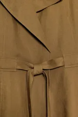 Chaqueta estilo trench corta color azul marino confeccionada con lino. Cuenta con cuello solapa, manga larga con trabilla, bolsillos delanteros de vivo y cierre frontal con lazada ajustable en la cintura.