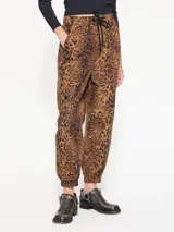 Pantalón babucha de algodón con estampado animal print, cintura elastizada con cordón de ajuste, puños elastizados y bolsillos plaque con tapa y broche snap negro.