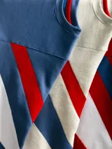 Buzo de algodón de corte premium con diseño de bloques de color en las mangas, cuello redondo y logo bordado en el pecho. Presenta costuras reforzadas y mangas anchas.