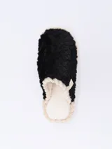 Pantuflas cerradas color negro con textura afelpada y borde trenzado color beige.