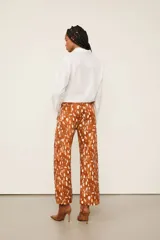 Pantalón ancho de algodón de tiro medio, con estampado animal print tipo ciervo en tonos tostado y blanco, diseño de cinco bolsillos y corte recto.