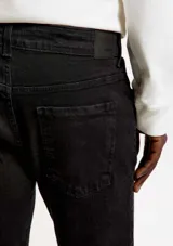Pantalón vaquero de corte ajustado en color negro, confeccionado en tejido de denim con elastano para mayor comodidad.