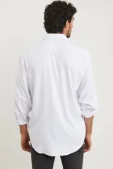 Camisa de vestir para hombre, color azul claro, de manga larga y cuello italiano. Tejido texturado y suave, confeccionada en una mezcla de algodón y poliéster.