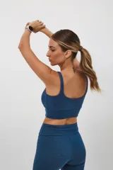 Top deportivo verde oliva con espalda cuadrada y corte ancho debajo del busto.