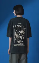 Remera de algodón premium con efecto nevado, corte oversize y cuello redondo. Presenta una estampa gráfica en la espalda con motivos de escorpión, rosa y tipografía en color crema.
