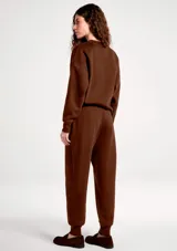 Pantalón deportivo tipo babucha color marrón, con cintura elástica ajustable mediante cordón y puños acanalados en los tobillos.