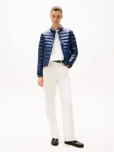 Campera azul marino ultraligera con relleno de plumón, cuello perkins, cierre de cremallera, dos bolsillos laterales con cremallera, puños con botón y sello de Tommy Hilfiger en la manga.