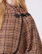 Ruana tejida de Jones New York con diseño a cuadros en tonos verdes y marrones. Presenta cuello alto, cierre frontal con botón tipo trenca y bordes con ribete negro.