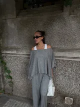 Blusa de lanilla gris con diseño asimétrico de un solo hombro y corte holgado tipo capa.