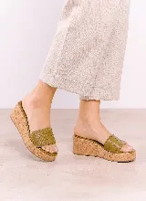 Sandalia de plataforma de corcho color verde oliva, confeccionada en cuero vacuno con capellada tejida en diseño entramado.