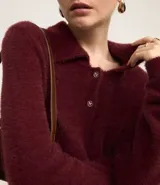 Saco de punto afelpado color bordó, de manga larga, con cuello polo y cierre frontal de dos botones.