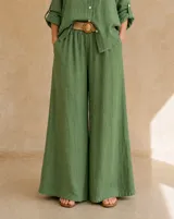 Pantalón verde de lino con diseño de pernera ancha, tiro alto, cintura elástica y bolsillos laterales.